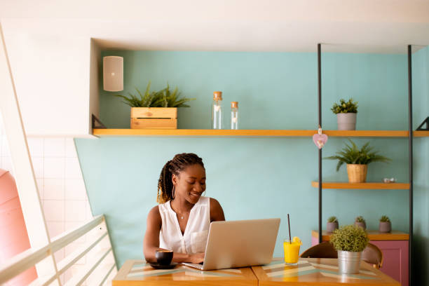 istock Young black woman drinking coffee  while working on laptop in the cafe 1494575043