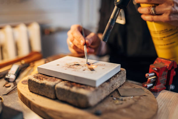 istock Unrecognizable goldsmith working with a unfinished work. A jeweler at work processes metal. Goldsmith work, welding, metal processing 1494576663