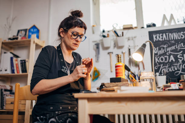 istock Female blacksmith uses a hand tool while making handmade jewelry in the workshop 1494577163