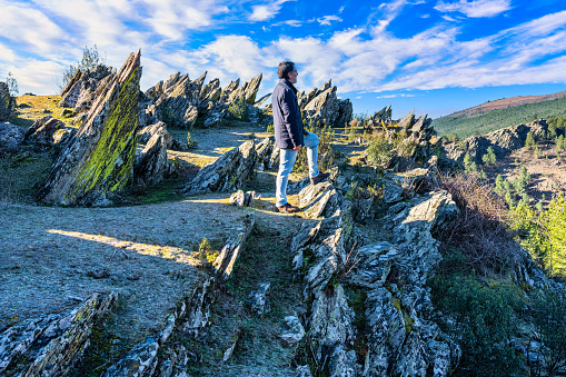 Hiking man resting in a strange landscape full of sharp rocks in the Sierra del Rincon, Madrid