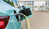 Electric car in the parking lot, connected to a charging station