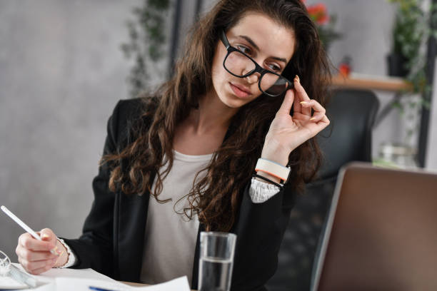 istock Businesswoman Checking In Client Replies While Filling In Work Log Book For The Day 1494578393