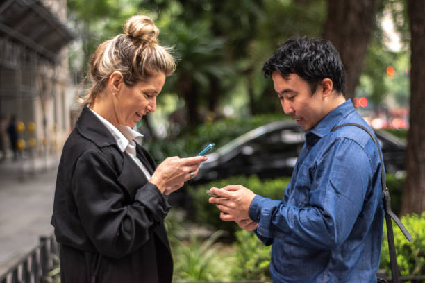 istock Coworkers using mobile phone while talking in the city 1494579015