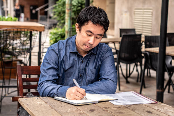 istock Mid adult man make annotations on his notepad at coffee shop 1494579298