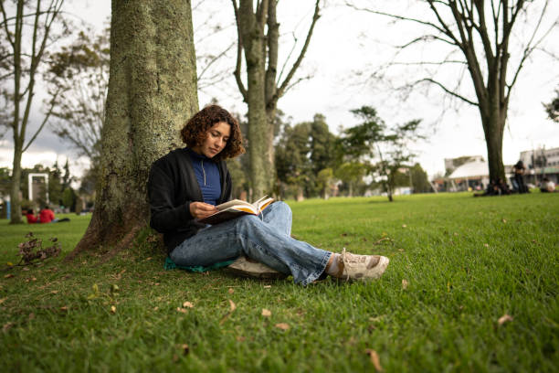 Young woman reading a book in the park