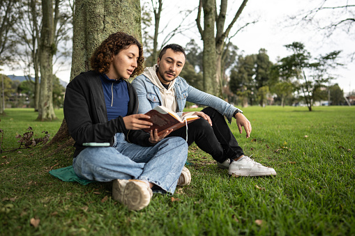 Young couple reading a book in the public park