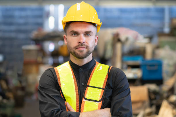 istock Young factory worker in hard hat sdaning at industry site 1494581206