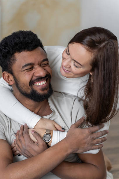 wieloetniczna amerykańska para obejmująca się w domu. - african descent sex symbol couple sensuality zdjęcia i obrazy z banku zdjęć