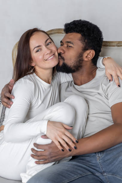 wieloetniczna amerykańska para obejmująca się w domu. - african descent sex symbol couple sensuality zdjęcia i obrazy z banku zdjęć