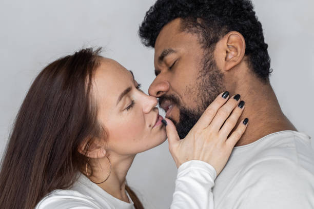 wieloetniczna para patrzy na siebie na szarym tle. czarny mężczyzna i kobieta rasy kaukaskiej kochają związek seksualny - african descent sex symbol couple sensuality zdjęcia i obrazy z banku zdjęć