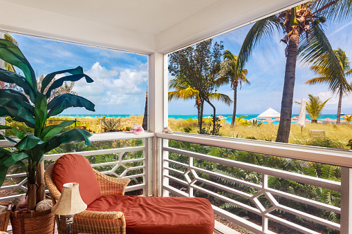 Comfortable chair in the corner of a screened porch overlooking the dunes and Grace Bay Beach, Turks and Caicos