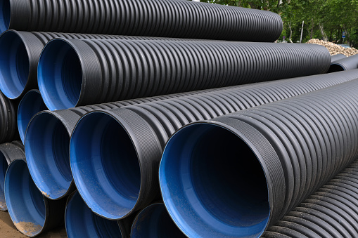 Close-up of large plastic corrugated pipes for water supply. Reconstruction of the pipeline and sewerage in the city.