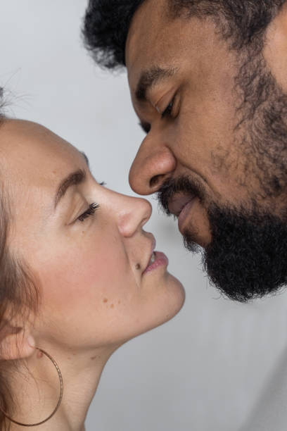 wieloetniczna para patrzy na siebie na szarym tle. czarny mężczyzna i kobieta rasy kaukaskiej kochają związek seksualny - african descent sex symbol couple sensuality zdjęcia i obrazy z banku zdjęć