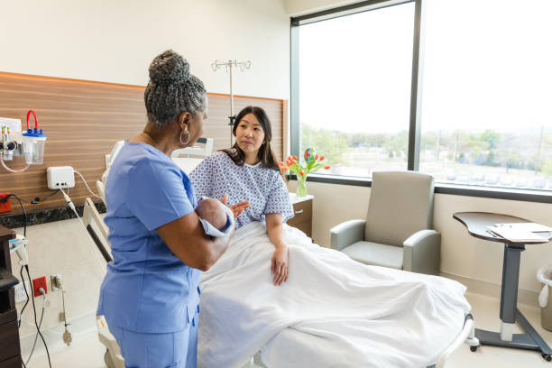 istock Senior nurse holds newborn while answering new mom's questions 1494582912