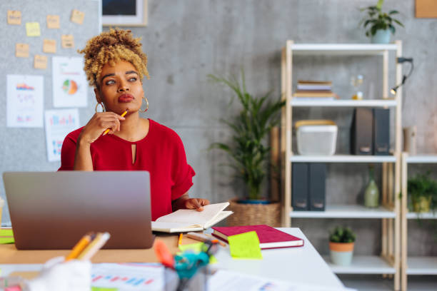 istock Young African-American woman thinking while sitting at office desk 1494588526