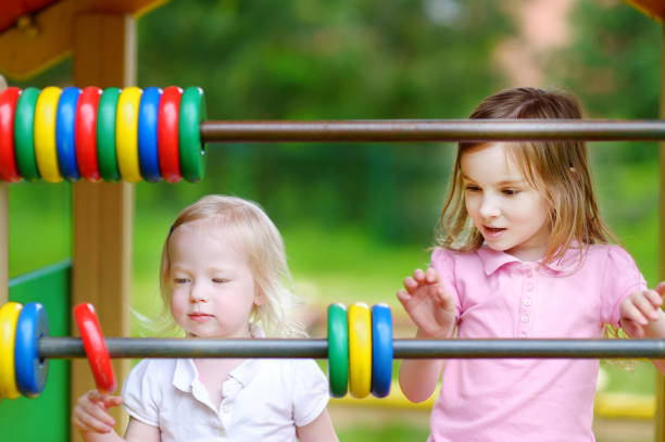 istock Two little sisters learning to count using giant abacus in a playground 1494589025