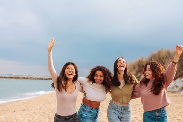 istock Four happy girls jumping while walking down the beach 1494590237