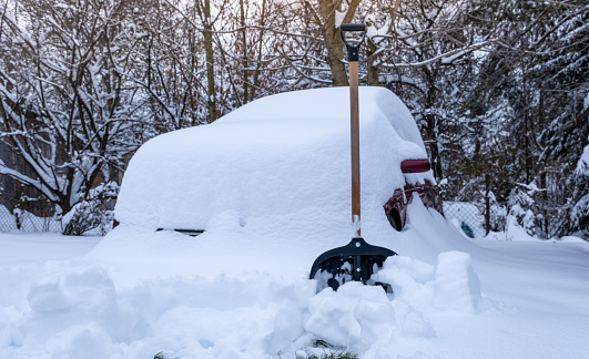 A large snow cap on the car - a car buried by snow powder