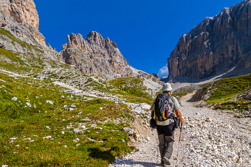 Hiker walking at the foot of the Catinaccio, Dolomites. Trentino-Alto Adige, Italy