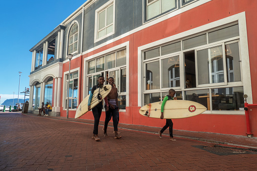 Cape Town 19 January 2023. Surfers walk back from the beach at Surfers Corner in Muizenberg. Muizenberg, Surfers Corner is an internationally renowned surfing spot for learner and pro surfers.