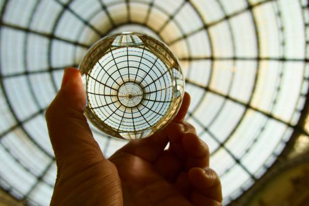 istock Hand holding crystal ball against glass ceiling 1494595304