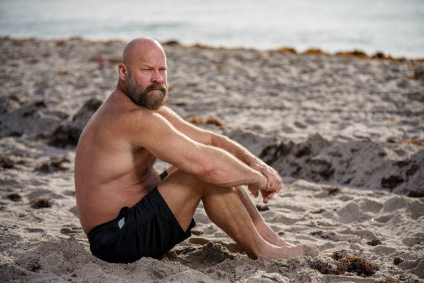 hombre con barba relajándose en la playa - handsome man flash fotografías e imágenes de stock
