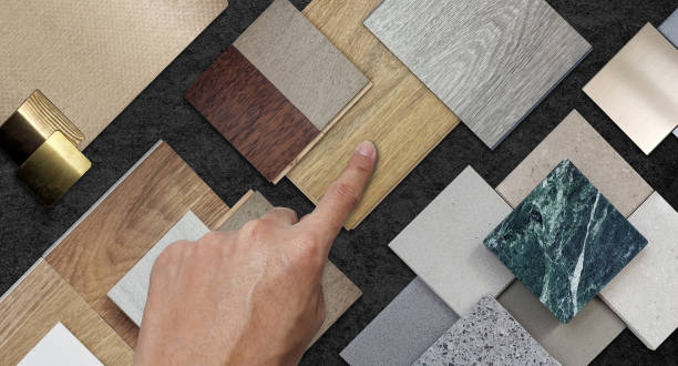 istock architect's hand selecting material samples contains stainless, metallic laminated, wooden vinyl flooring tiles, laminated tiles, marble stone, stone tiles placed black marble table background. 1494600797
