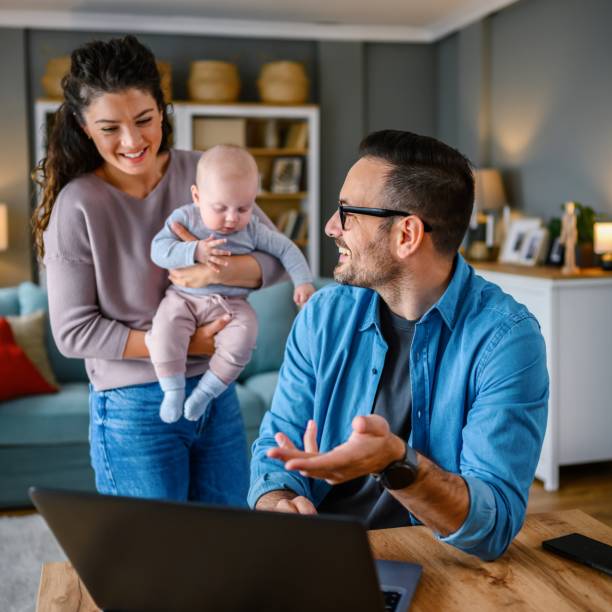 istock Family with a baby at home, Father using a laptop. 1494600900