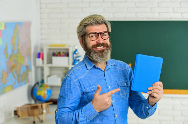 Back view of male professor giving lecture to high school students in the classroom.