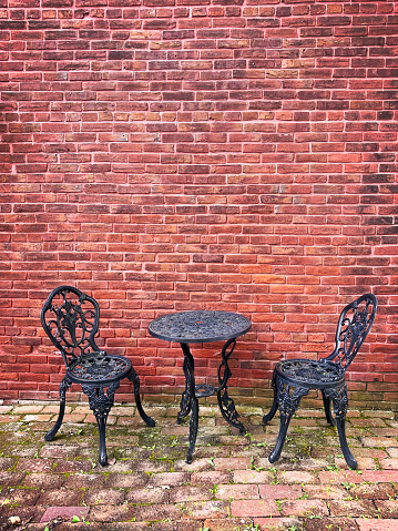 Patio table and chairs in front of a brick wall