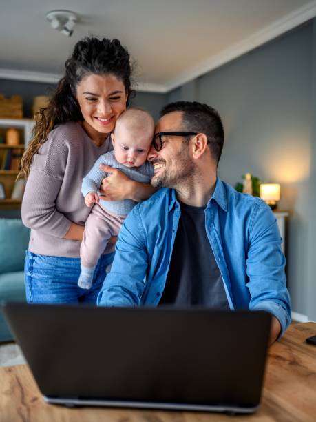 istock Family with a baby at home, Father using a laptop. 1494602690