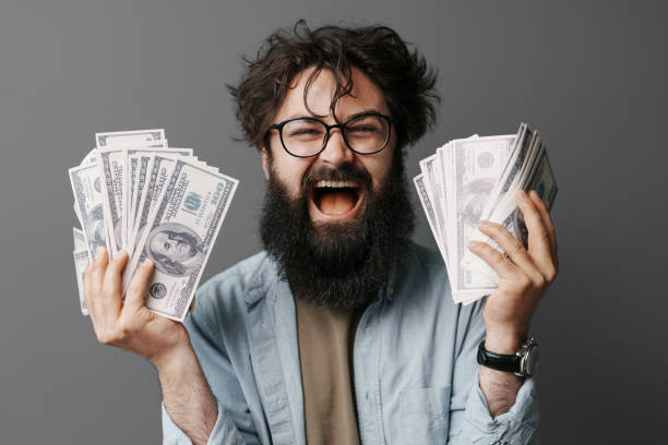 istock Handsome bearded man holds money in hand 1494602940