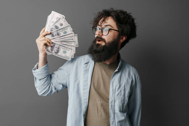 istock Handsome bearded man holds money in hand 1494602982