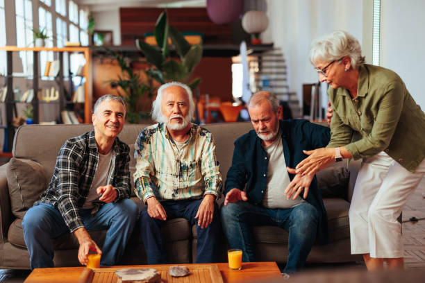 istock Four senior people having conversation while resting in living room 1494603264