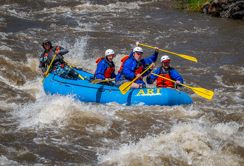 Canon City, CO, USA - May 29, 2023: Small groups of people in inflatable rafts, enjoying the challenge of the whitewater rapids on the Arkansas River through Bighorn Canyon near Canon City on Memorial Day, 2023 after a winter and spring of abnormally high precipitation.