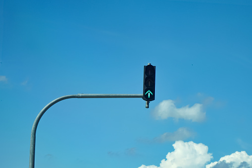 Traffic lights at a junction with blue sky background