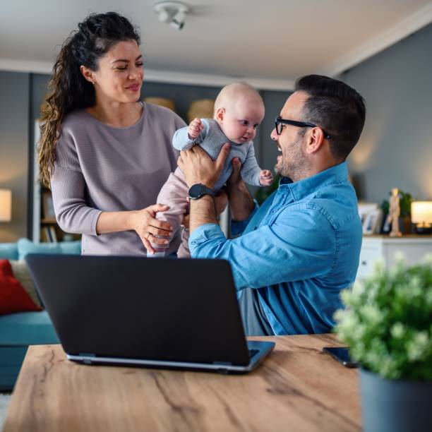 istock Family with a baby at home, Father using a laptop. 1494606021