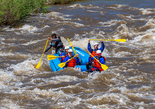 Canon City, CO, USA - May 29, 2023: Small groups of people in inflatable rafts, enjoying the challenge of the whitewater rapids on the Arkansas River through Bighorn Canyon near Canon City on Memorial Day, 2023 after a winter and spring of abnormally high precipitation.
