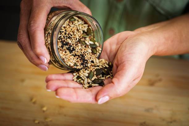 Healthy seeds and nuts on the palm of hand stock photo
