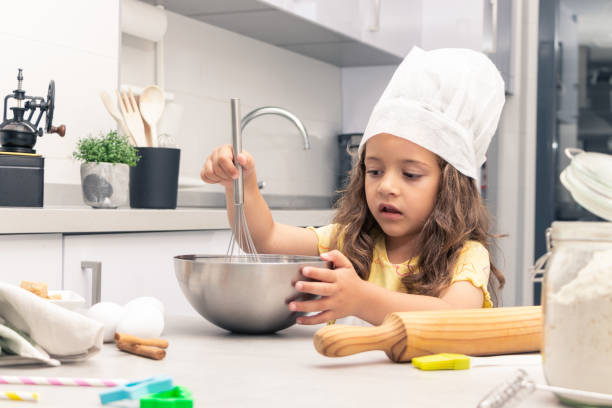 istock Baking Magic: Girl Transforming Ingredients into Tempting Pastries in the Kitchen 1494617915