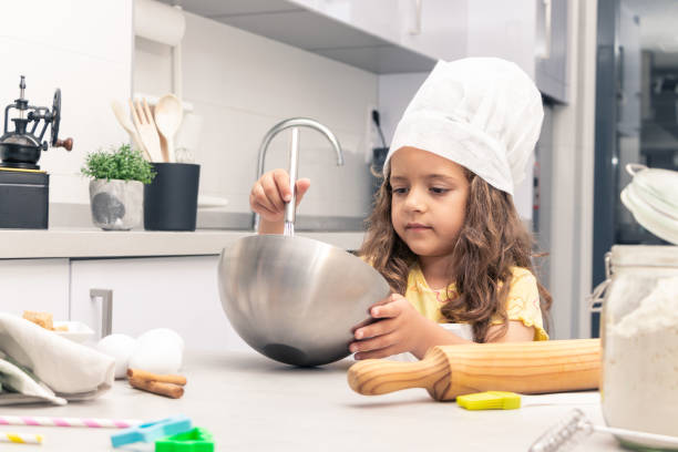 istock Sweet Delights: Girl Channeling her Inner Chef with Baking Skills in the Kitchen 1494617921