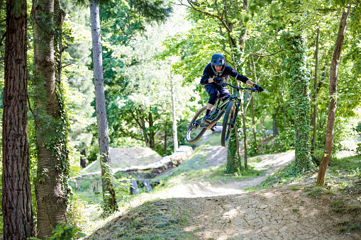 guy is jumping with his mountain bike in the bikepark.