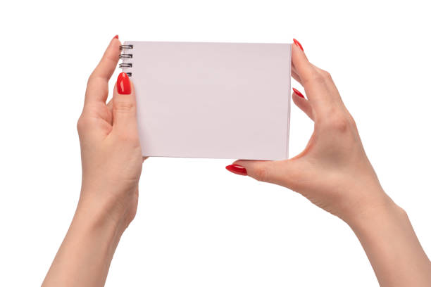 istock A notebook with empty white paper in woman hands with red nails. 1494621569