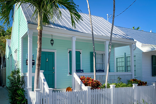 Picturesque house with palm trees in the streets of Key West, Florida, USA against blue sky