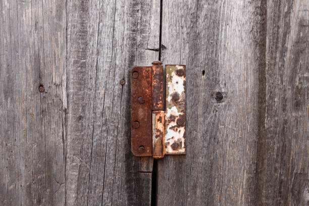 Old rusty hinge on a wooden door. Old rustic background.