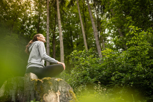 istock Young woman feeling at peace in a green nature forest setting. 1494624518