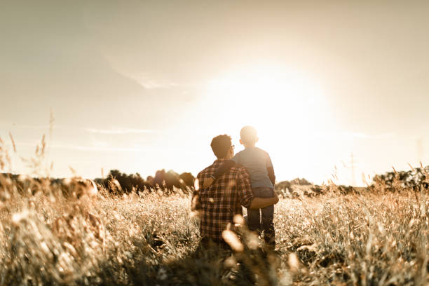 istock Father and son out in a field enjoying nature at sunset. 1494624963