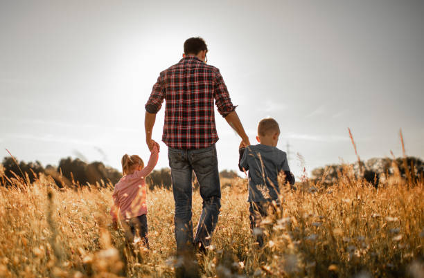 istock Father walking in nature meadow with his children. 1494625029