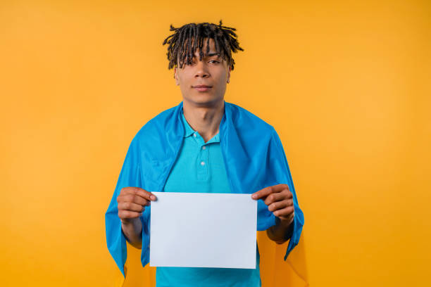 istock Handsome ukrainian man holding horizontal white a4 paper poster. Copy space. 1494625210