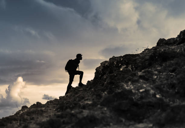istock Male hiker climbing up the mountain. 1494625258